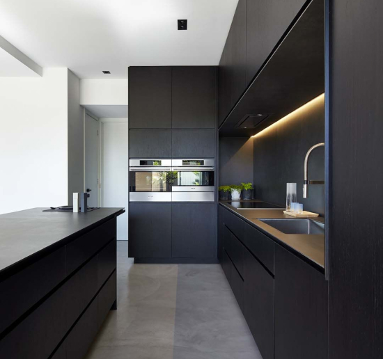a kitchen with black cabinets and a sink